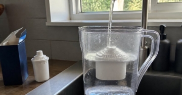 Wasserfilterkanne am Wasserhahn befüllt