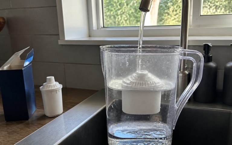 Wasserfilterkanne am Wasserhahn befüllt